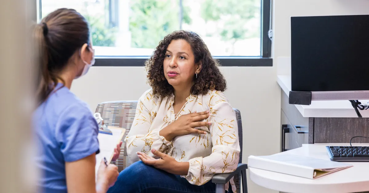 Perimenopausal woman talks with healthcare provider about her symptoms.