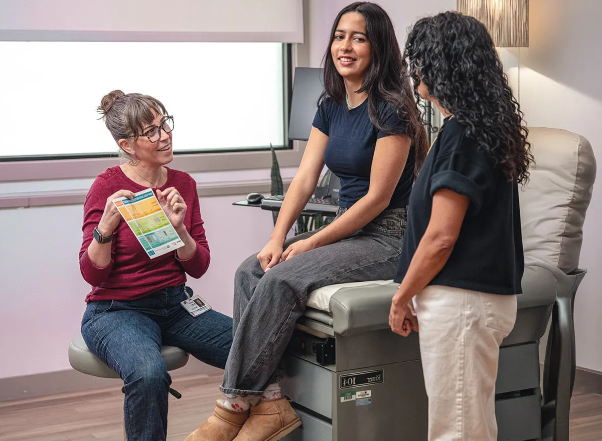 Nurse-midwife discussing reproductive health chart with patient.