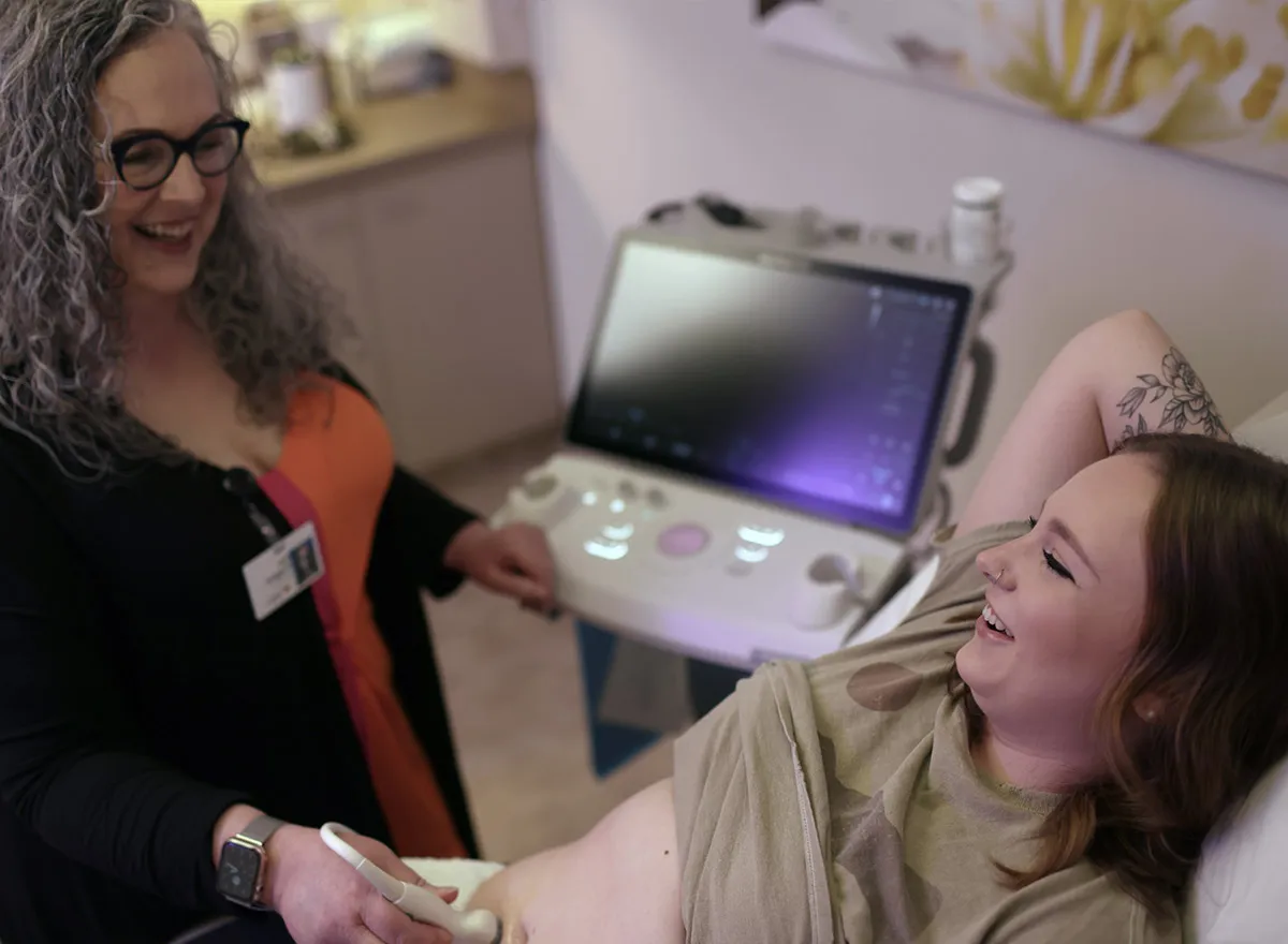 Clinician performing prenatal ultrasound for pregnant patient.