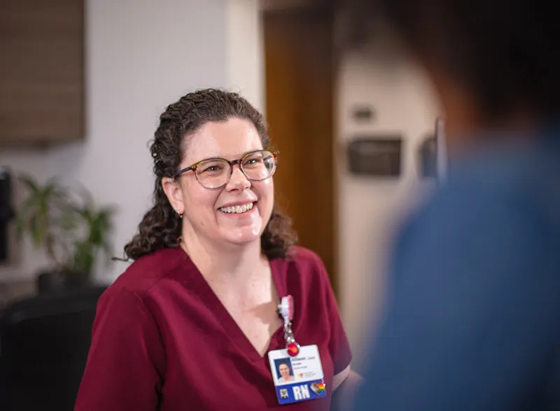 Registered nurse speaking with patient during clinic visit.